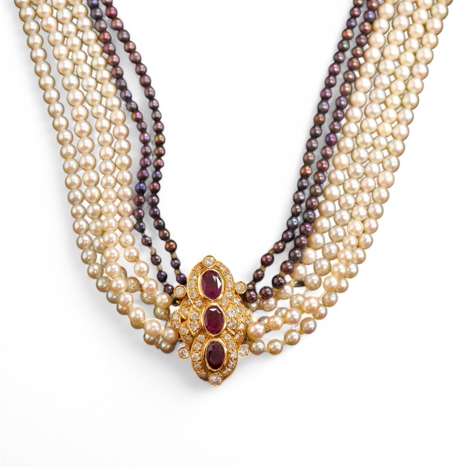 A cultured pearl, ruby and diamond necklace, the clasp set with oval rubies and brilliant-cut diamonds, to a six-strand torsade necklace of cultured pearls of black and white tints, necklace length 61cm, clasp length 2.5